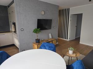 a living room with a tv and a table and chairs at ApartPodmiejska in Kalisz