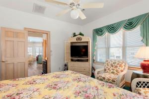 a bedroom with a bed and a tv and a chair at Fergusons Flagship in Nags Head +42 photos