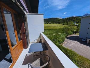 ein Balkon mit Tisch und Stühlen und einem Fenster in der Unterkunft Appartement chic et cosy au pied du village in Villard-de-Lans