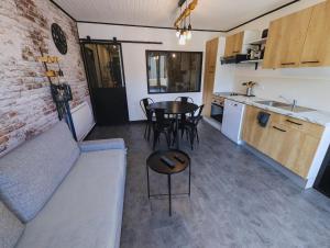 ein Wohnzimmer und eine Küche mit einem Tisch und einer Couch in der Unterkunft Appartement chic et cosy au pied du village in Villard-de-Lans