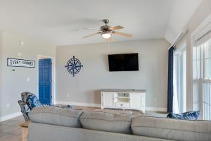 Una sala de estar con un sofá y un televisor de pantalla plana. en First Flight Retreat 105, en Kill Devil Hills