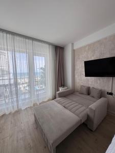a bedroom with a large bed and a large window at TGM Sunrise View in Infinity Pool & Spa Resort in Mamaia Sat/Năvodari