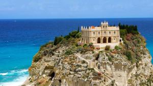 a building on the side of a cliff next to the ocean at Residenza Rivellini Tropea in Tropea