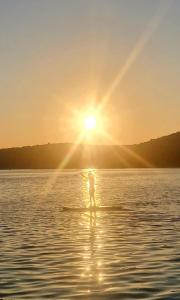 a person on a paddle board in the water at sunset at Sunset Apartment in Sevid
