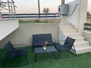 un patio con 2 sillas, una mesa y escaleras en Re-Treat, en Nea Fokea