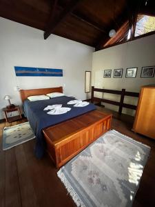 a bedroom with a bed with a blue comforter at Chalé Igraine in Camanducaia +26 photos