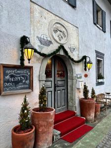 eine Eingangstür eines Gebäudes mit Weihnachtsbäumen in Töpfen in der Unterkunft Apartments Belopeški Dvori in Kranjska Gora
