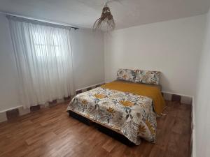 um quarto com uma cama em um quarto com piso de madeira em Dar sidi laghazi em Essaouira
