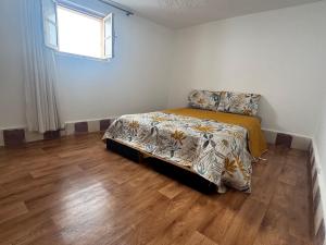 um quarto com uma cama e piso de madeira em Dar sidi laghazi em Essaouira