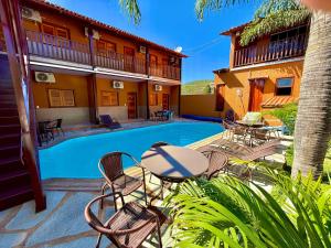 a patio with a table and chairs next to a pool at Pousada Estrela Guia in Pirenópolis