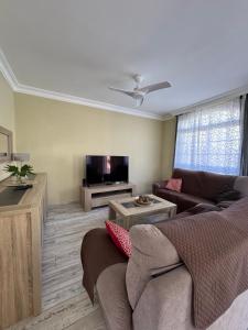 a living room with a couch and a flat screen tv at Villa Lady#Luxury Costa Adeje in Adeje
