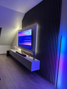 a living room with a large flat screen tv on a wall at Flex Apartments Blue in Mosonmagyaróvár +20 photos