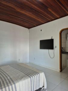 a bedroom with a bed and a flat screen tv on the wall at Apartamento Centro Cívico in Boa Vista