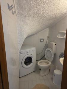 a bathroom with a washing machine and a toilet at Bright & Bloom maisonette in Hanioti +22 photos