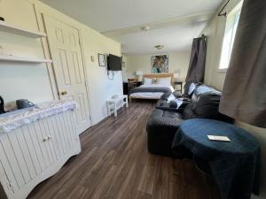 a living room with a black leather couch and a bedroom at Objectif Santé in Longueuil