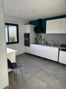 a kitchen with white cabinets and a sink at La Résidence Degas 4 chambres in Joué-lès-Tours
