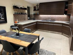 a kitchen with a wooden table and chairs and a counter at chez Kay in Vétraz-Monthoux +10 photos