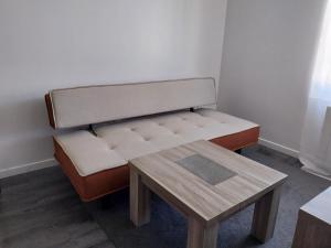 eine Bank mit einem Tisch in einem Zimmer in der Unterkunft Le Figuier in Le Mans