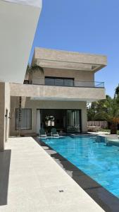 a house with a swimming pool in front of a building at Villa Kaima Marrakech jacuzzi chauffé in Marrakesh