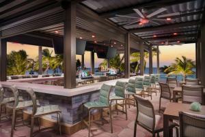 a bar on the beach with chairs and tables at Courtyard by Marriott Oceanside Fort Lauderdale Beach in Fort Lauderdale
