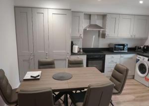 Una cocina con una mesa y sillas en una cocina. en Coastal Serenity, en Portrush