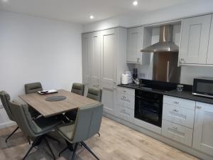 Una cocina con mesa y sillas y un microondas. en Coastal Serenity, en Portrush