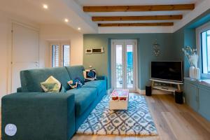 ein Wohnzimmer mit einer blauen Couch und einem Fernseher in der Unterkunft Nido Blu - Vista Lago in Belgirate