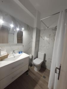 a white bathroom with a sink and a toilet at Galazio suites 3 Seaside in Salamina +14 photos