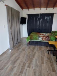 a bedroom with a bed and a wooden floor at Mi lugar en el mundo in Cortaderas