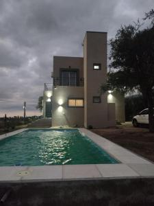 a house with a swimming pool in front of a house at Mi lugar en el mundo in Cortaderas +10 photos