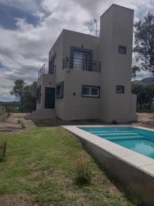 a house with a swimming pool in front of it at Mi lugar en el mundo in Cortaderas