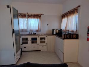 a kitchen with white cabinets and a microwave at Mi lugar en el mundo in Cortaderas