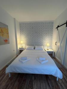 a bedroom with a white bed with two towels on it at Apartman Chilla 2 in Veliko Gradište