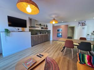 a kitchen and living room with a table and chairs at Pueblo Bonito Epinal avec Terrasse in Épinal +9 photos