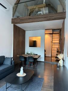 a living room with a couch and a table at Au bât Tournai Appart in Tournai