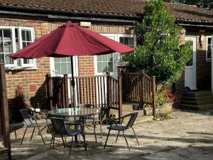 a patio with a table and chairs and an umbrella at Griffin Chalets in Southampton