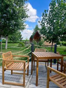 a wooden table and two benches on a deck at Ritopia Glamping in Kovilj