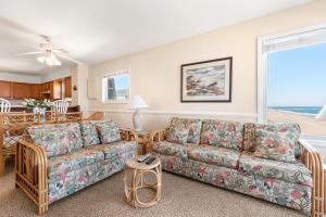 a living room with a couch and a table at Golden Strand Unit C3 in Kill Devil Hills +27 photos