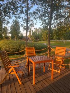 two chairs and a wooden table and chairs on a deck at Ritopia Glamping in Kovilj