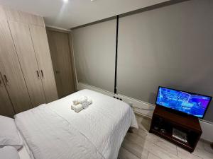 a bedroom with a bed and a flat screen tv at STUDIO Luxury View Edificio Harmony in Quito +31 photos