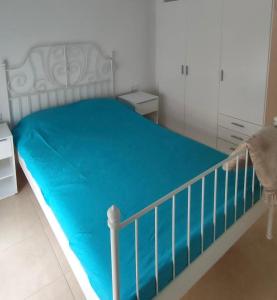 Un dormitorio con una cama con una manta azul. en 2 slaapkamer appartement in alhoceima bades, en Alhucemas
