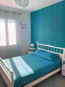 Schlafzimmer mit blauen Wänden und einem Bett in der Unterkunft Maison plain-pied au calme proche lac de miel Wifi gratuit in Beynat + 23 Fotos