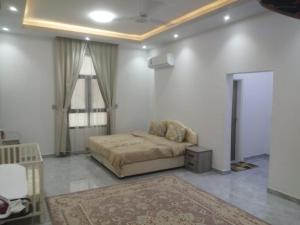 a bedroom with a bed in a room with a rug at ظفار صلاله عوقد الشماليه in Salalah
