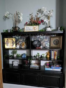 a black book shelf with books and plants on it at Walk to Trinity Hartford 2BR Gem Barry Square in Hartford