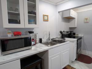 a kitchen with a sink and a microwave at Walk to Trinity Hartford 2BR Gem Barry Square in Hartford +12 photos