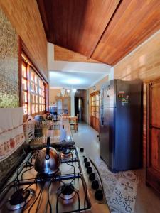 a kitchen with a stove and a stainless steel refrigerator at Casa em Santo A do Pinhal, vizinha à Campos do Jordão in Santo Antônio do Pinhal