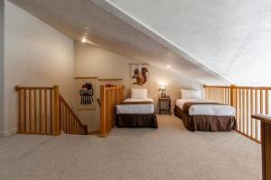 a attic room with two beds and a staircase at Crestview Condominiums by All Seasons Resort Lodging in Park City +122 photos
