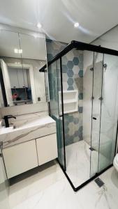 a bathroom with a glass shower and a sink at Studio Patteo Helbor 21 in Guarulhos +10 photos