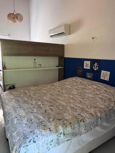 een slaapkamer met een bed met een dekbed bij Flat Palmeira-Pipa Solar - centro in Tibau do Sul +5 foto's
