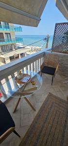 a balcony with a table and chairs and a view of the beach at Charlie Chaplin luxury apartments in Perea